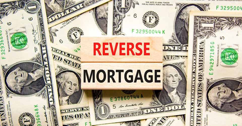 Reverse mortgage words on wooden blocks and dollar bills background