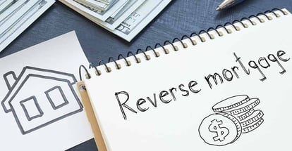 Reverse mortgage written on a notebook and dollar bills