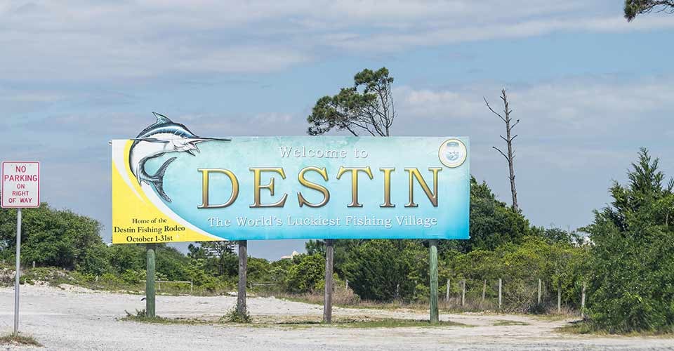 Road sign with Welcome to Destin the Worlds luckiest fishing village in Florida
