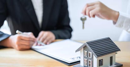 Sale agent giving house key to new client after signing agreement