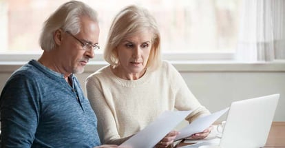 Senior couple reading mortgage documents