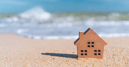 Small home model on sand beach