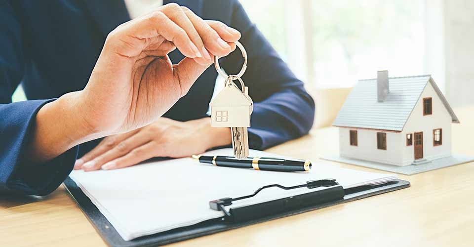 Small house model with real estate agent and customer discussing for contract to buy house
