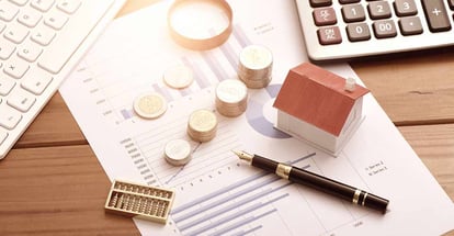 Small houses coins and documents on a table