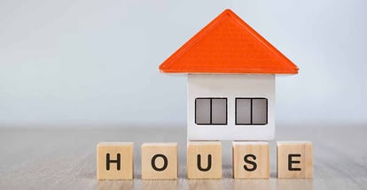 Small model home and house word written on wooden cube