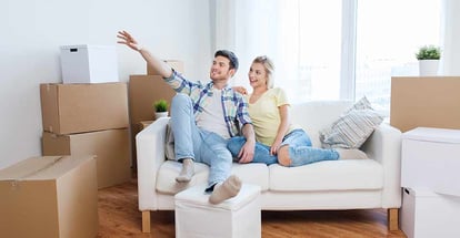 Smiling couple with boxes moving to new home