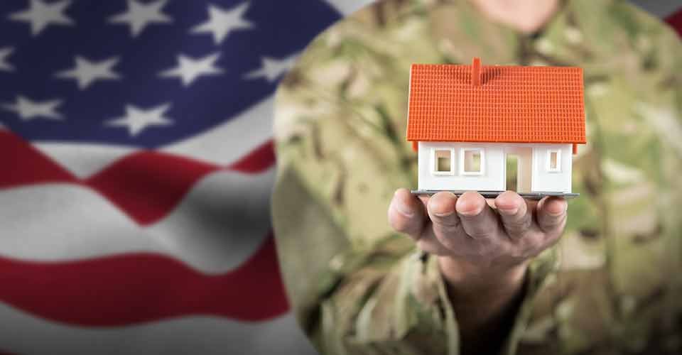 Soldier holding model house against usa flag
