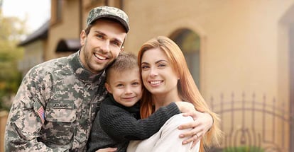 Soldier with his family on a sunny day outside new house