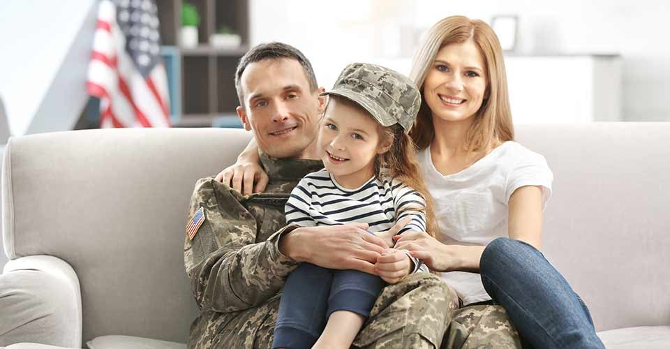 Soldier with his family sitting on sofa at new home