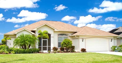 Southwest Florida concrete block and stucco home in the countryside with tropical plants and flowers