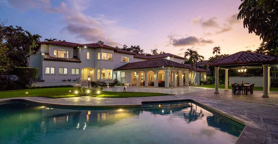 Spanish mansion with sky at dusk and a great pool for swimming in Miami Florida