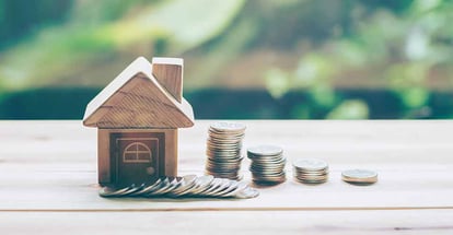 Stack coins lined up in front of model house