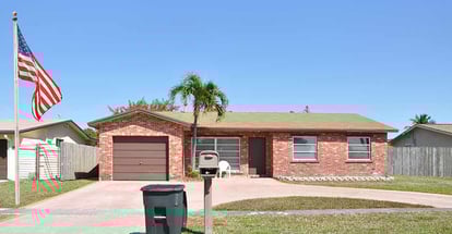 Suburban Brick Ranch style home with American flag