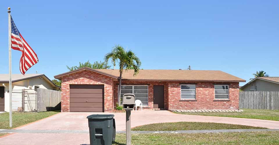 Suburban Brick Ranch style home with American flag