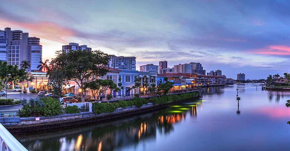 Sunset over the colorful shops of the Village on Venetian Bay in Naples Florida