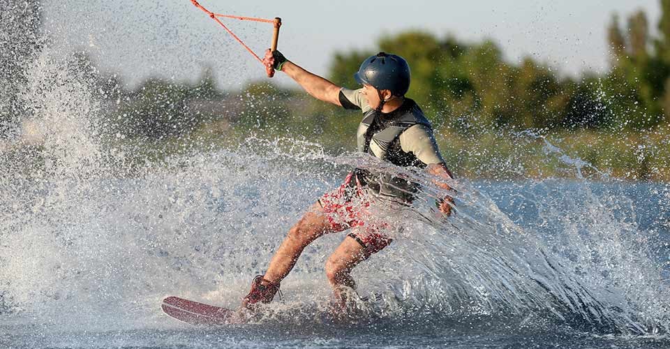 Teenage boy wakeboarding on lake