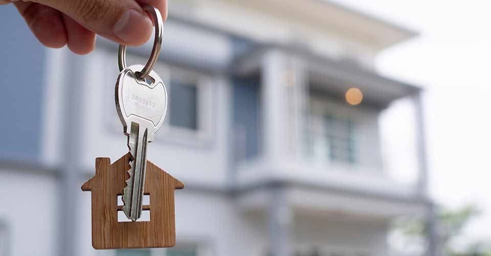 The owner holds a new home key from a real estate dealer
