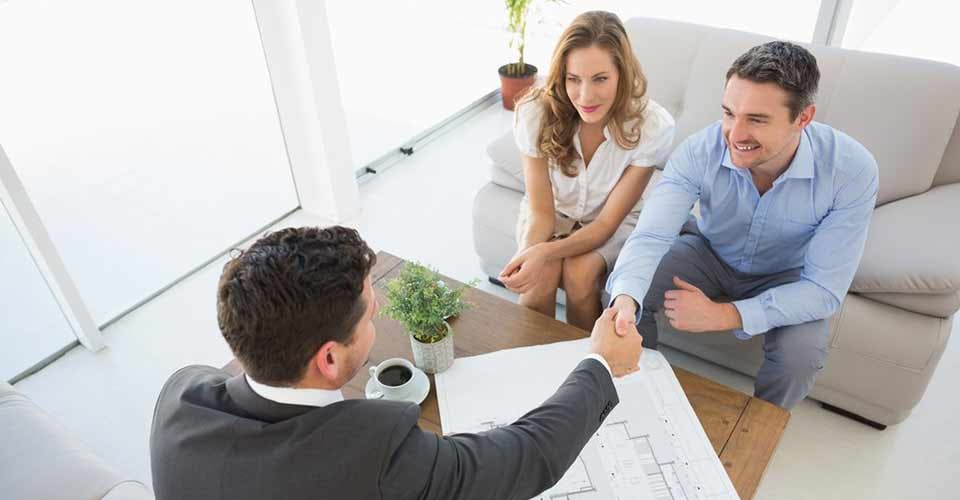 Top view of a smiling young couple in meeting with a financial adviser at home