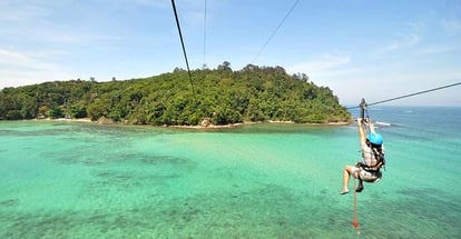Tourists ride the zipline