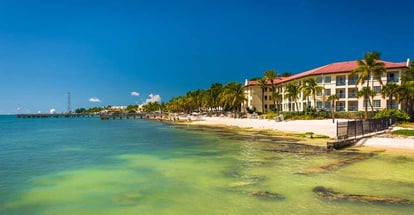 Turquoise waters of the Gulf of Mexico and buildings along the beach in Key West Florida