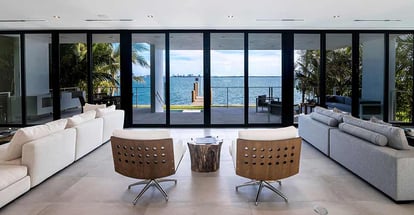 Two chairs fronting the waterfront views inside a modern living room of a contemporary house