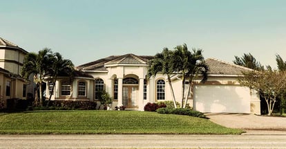 Typical Southwest Florida concrete block and stucco home in the countryside with tropical plants and flowers