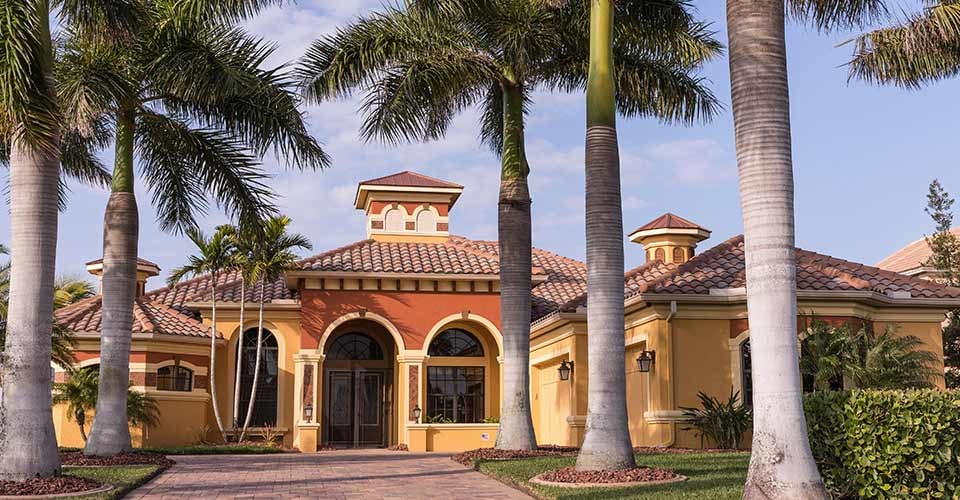 Typical Southwest Florida luxury concrete block and stucco home in the countryside with palm trees tropical plants and flowers