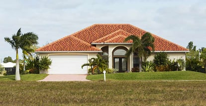 Typical concrete block and stucco home in the countryside with tropical plants in Florida