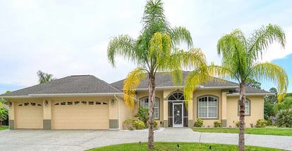 Typical concrete block home in the countryside with palm trees in Florida