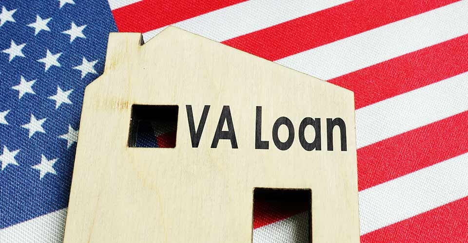 VA loan sign on the wooden home and American flag