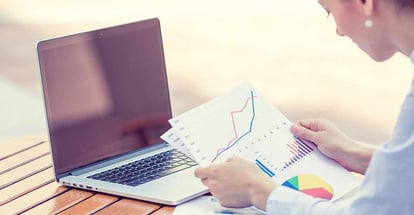 Woman analyzing financial report documents and graphs