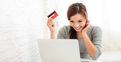 Woman enjoy online shopping paying by credit card