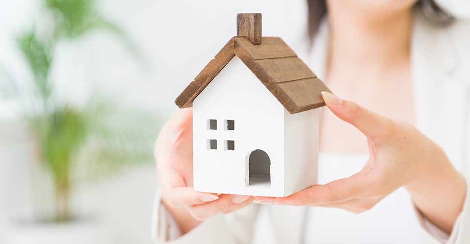 Woman holding a miniature house