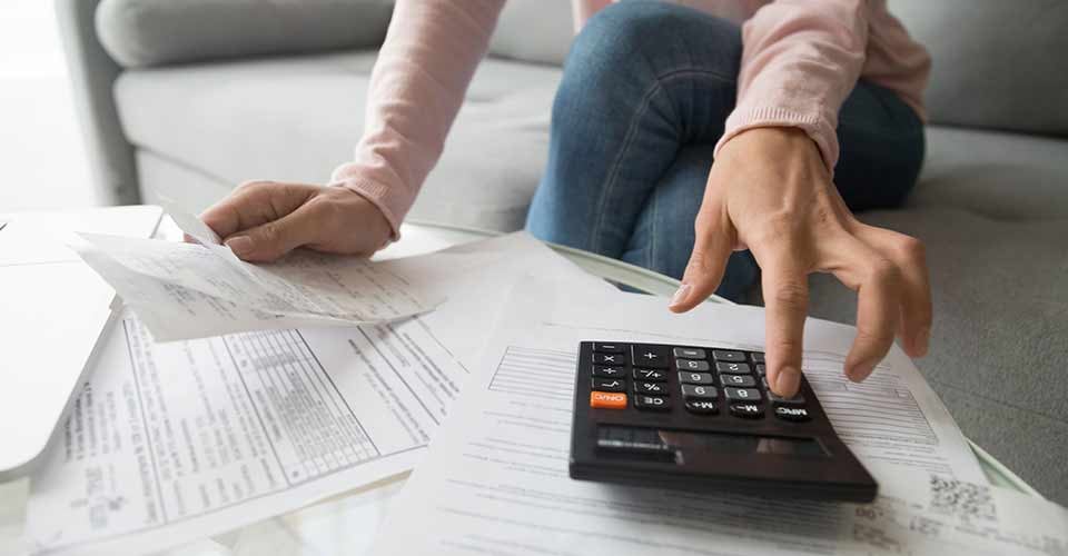 Woman holding mortgage paper and calculating closing cost