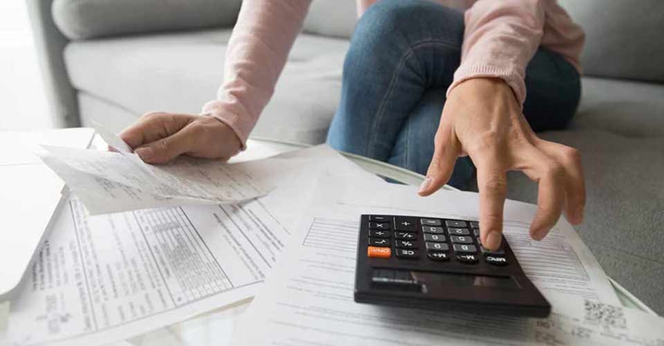 Woman holding mortgage paper and calculating