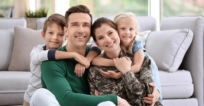 Woman in military uniform with her family at home