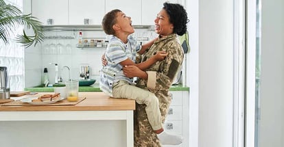 Woman laughing out loud while spending time with her little son at the kitchen