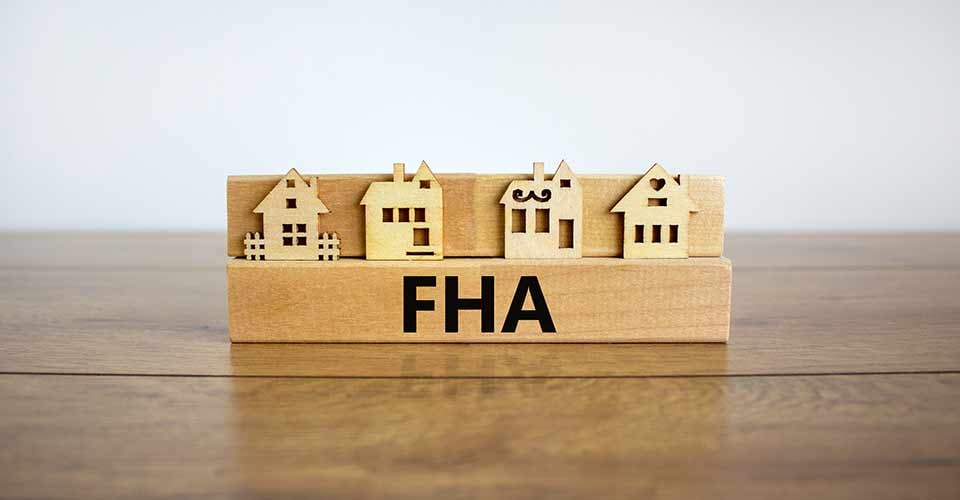 Wooden block with word FHA near modal houses