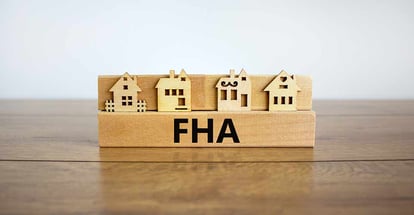 Wooden block with word FHA near modal houses