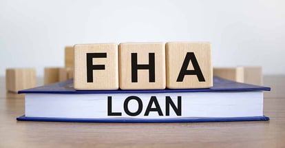 Wooden blocks with the words FHA loan and book on wooden table