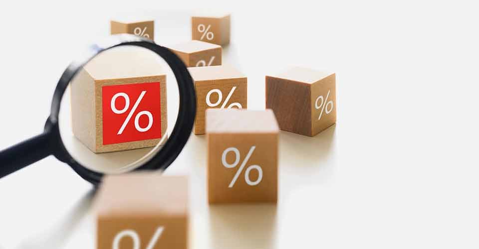 Wooden cube blocks with percentage symbol and magnifier