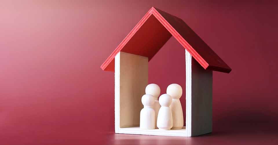 Wooden dolls family inside a model house