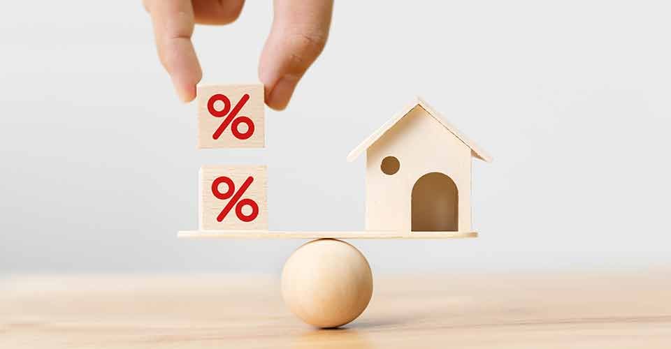 Wooden home and hand putting cube block shape with icon percent on wood scales