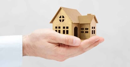 Wooden house model in hand