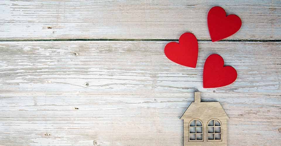 Wooden house with three red hearts