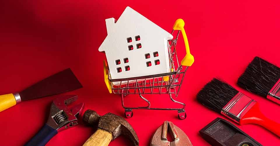 Wooden white house model and construction tools for home renovation