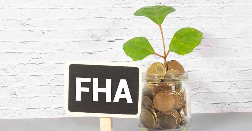 Word FHA written on blackboard and jar filled with coins
