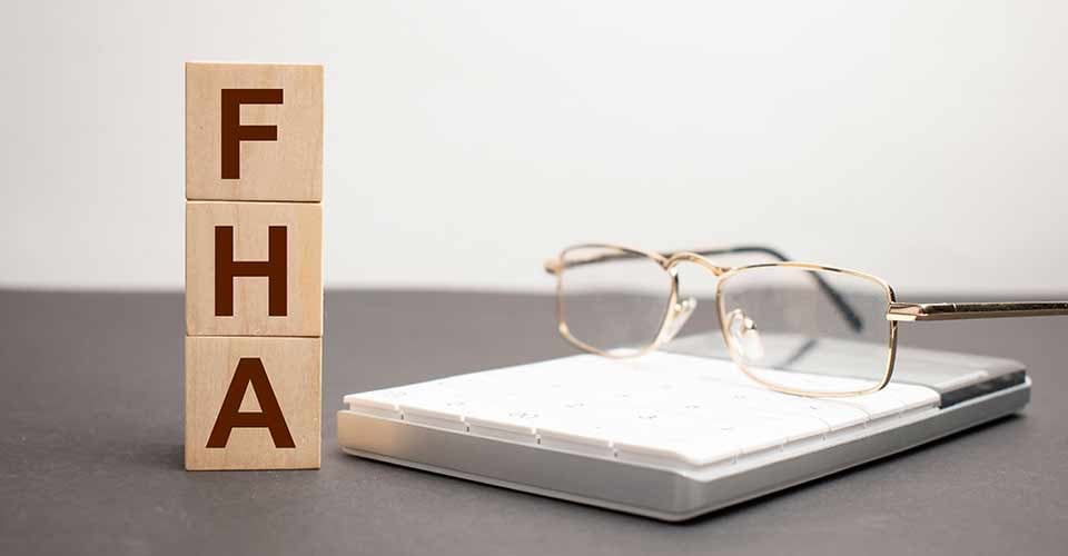 Word FHA written on wooden cubes with magnifying glass and documents