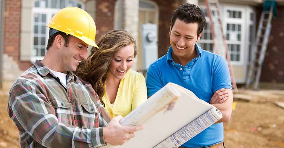 Young Couple Look at Home Renovation Plans with Builder