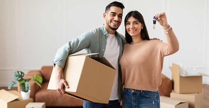 Young Couple Showing Keys And Holding Cardboard Box